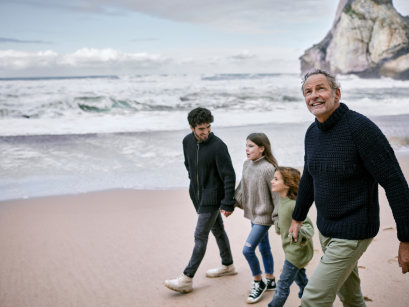 Multi-generational family walking on beach