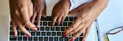 Close-up of adult and child hands typing on computer