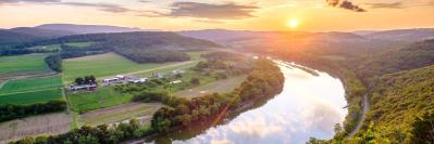 River flowing through valley at sunrise